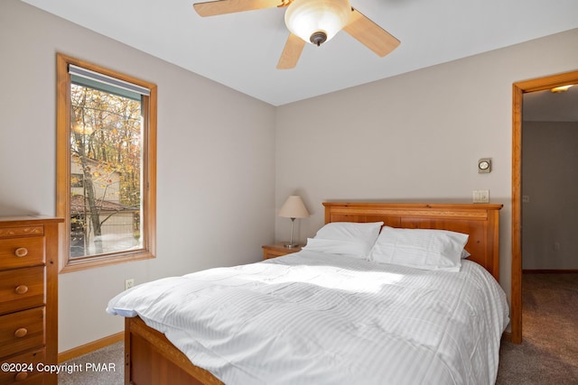 carpeted bedroom with ceiling fan and baseboards