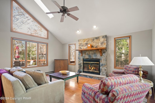 living room featuring a stone fireplace, wood-type flooring, high vaulted ceiling, a baseboard radiator, and ceiling fan