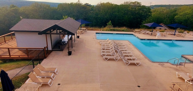 community pool featuring fence and a patio