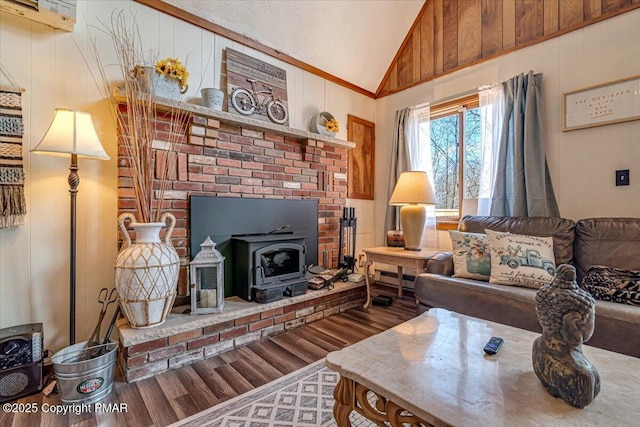 living area with vaulted ceiling, a wood stove, wood finished floors, and wooden walls