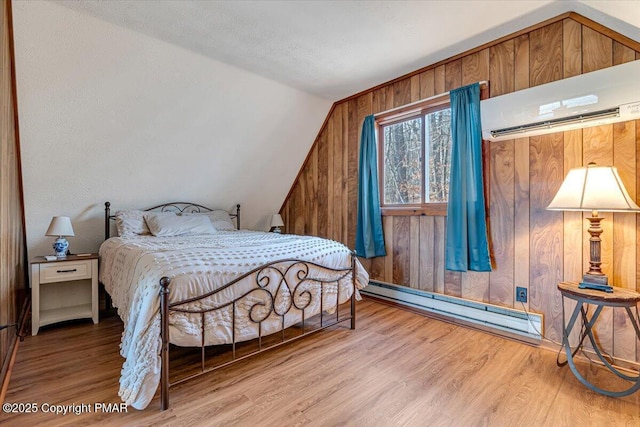 bedroom featuring an AC wall unit, vaulted ceiling, wood finished floors, wooden walls, and a baseboard radiator