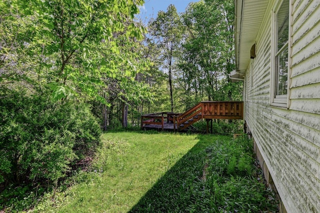 view of grassy yard featuring a wooden deck