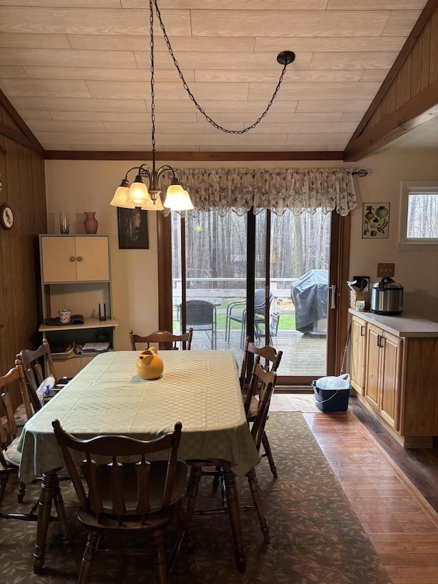 dining room with dark wood finished floors, a notable chandelier, vaulted ceiling, and wooden ceiling