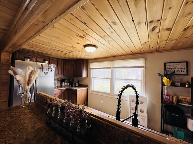 kitchen with wooden ceiling, freestanding refrigerator, and dark brown cabinetry