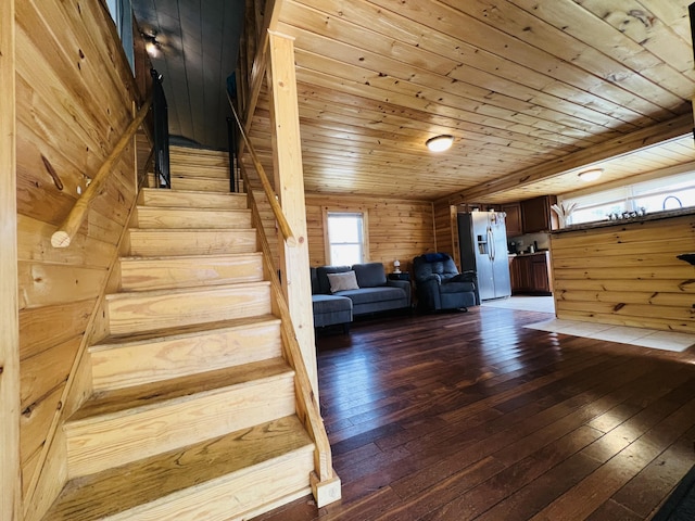 stairs with wood-type flooring, wooden walls, and wooden ceiling