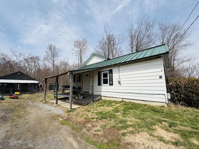 view of front of house featuring a front lawn and metal roof