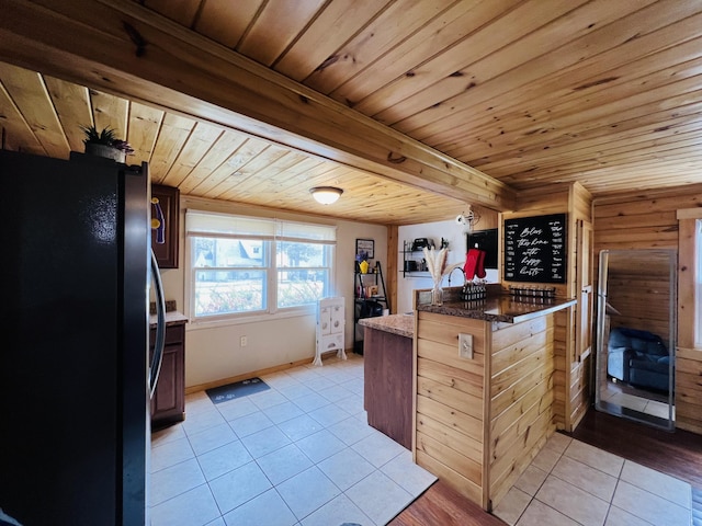 kitchen featuring freestanding refrigerator, wood ceiling, and light tile patterned floors
