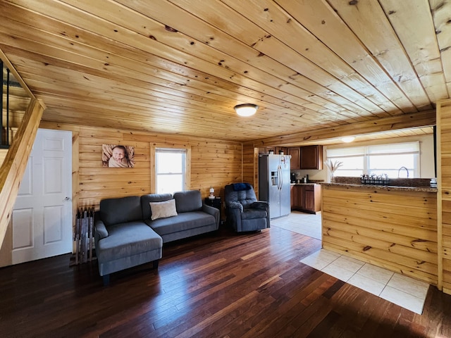 living area featuring wooden walls, light wood-type flooring, and wooden ceiling