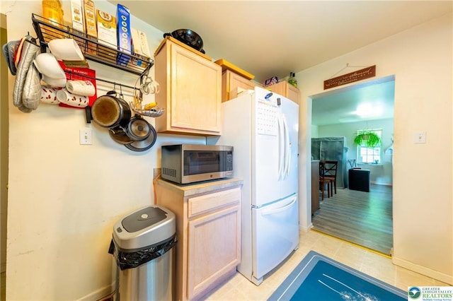 7112 Howell Ter, Stroudsburg, PA 18360 - kitchen featuring stainless steel microwave, freestanding refrigerator, light tile patterned floors, light brown cabinets, and light countertops