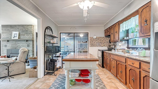 2125 Sassafras Ln, Kunkletown, PA 18058 - kitchen featuring stainless steel range with electric stovetop, crown molding, ceiling fan, light tile patterned floors, and brown cabinets