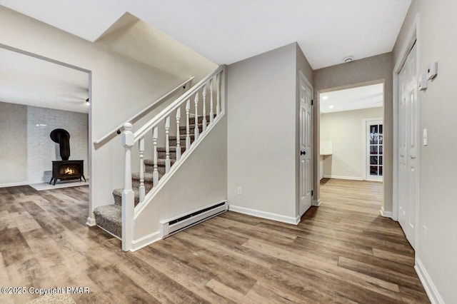 staircase with hardwood / wood-style flooring and a baseboard radiator