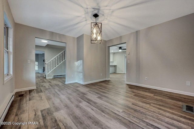 unfurnished room with ceiling fan, a baseboard radiator, and hardwood / wood-style floors