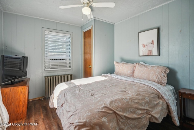 bedroom featuring radiator, ornamental molding, a ceiling fan, a textured ceiling, and wood finished floors