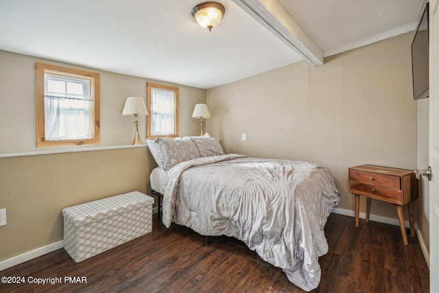 bedroom with beamed ceiling, wood finished floors, and baseboards