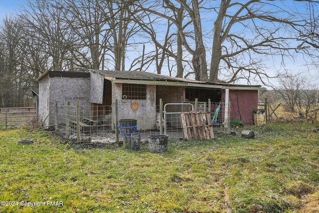 view of outbuilding featuring fence and an outdoor structure