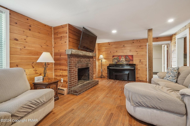 living area with wooden walls, hardwood / wood-style floors, a brick fireplace, a baseboard heating unit, and recessed lighting