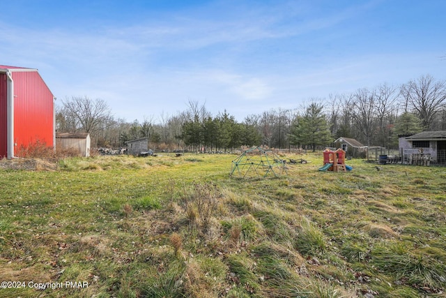 view of yard featuring a playground and an outbuilding