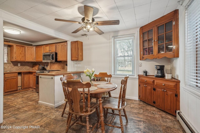 kitchen featuring brown cabinetry, decorative backsplash, a baseboard radiator, a peninsula, and stainless steel appliances