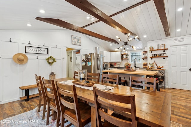 dining room with vaulted ceiling with beams, a chandelier, and light wood-type flooring