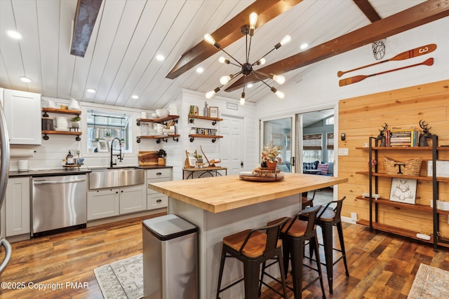 kitchen featuring wooden counters, open shelves, a sink, dishwasher, and a kitchen breakfast bar