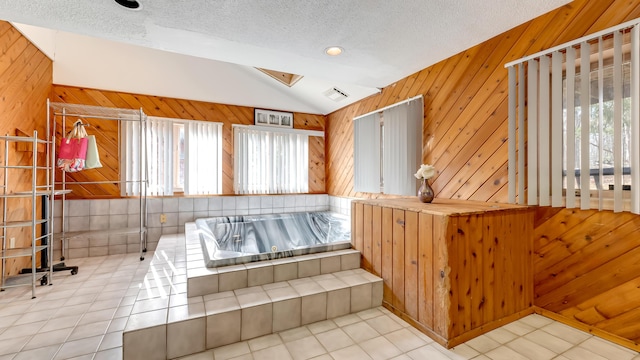 bathroom with lofted ceiling, a textured ceiling, wooden walls, and tile patterned flooring