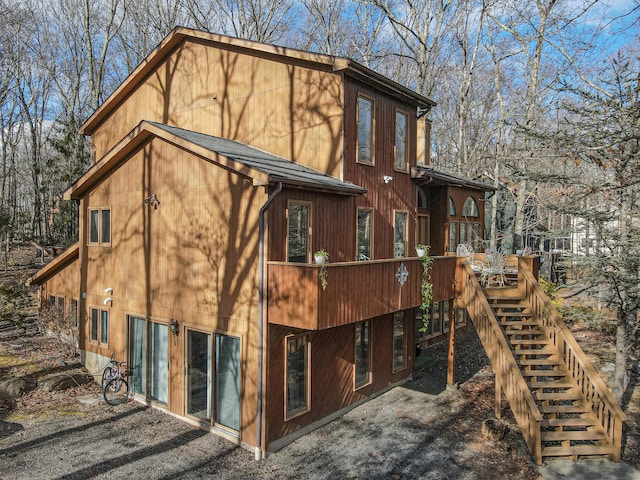 view of home's exterior with stairs and a deck