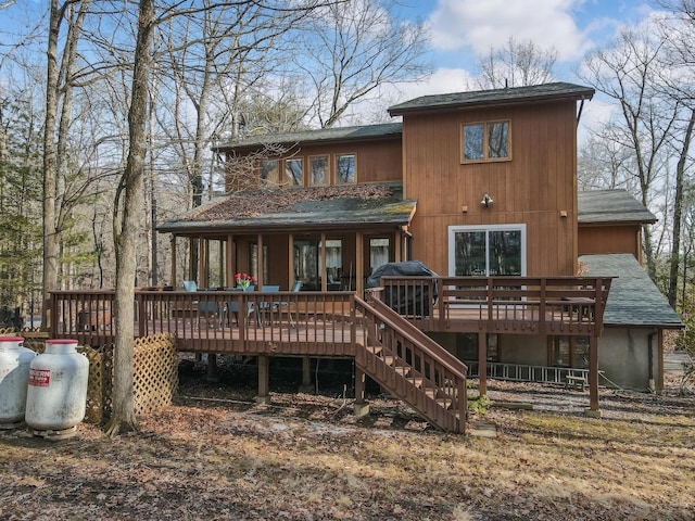 rear view of property featuring a wooden deck, stairway, and a shingled roof