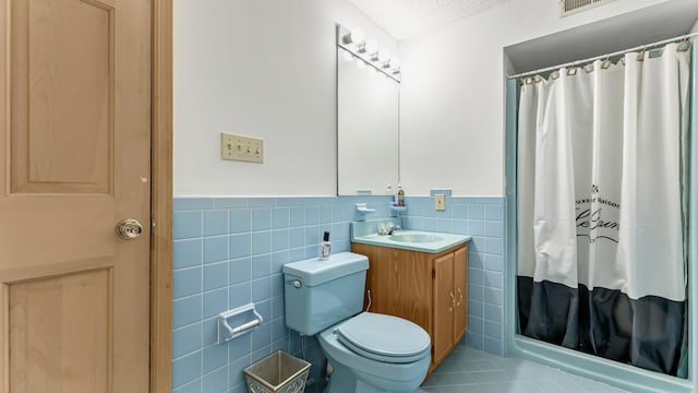 bathroom featuring tile walls, toilet, vanity, wainscoting, and a textured ceiling