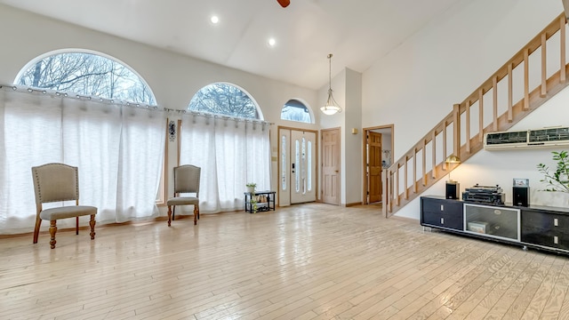 foyer entrance featuring stairway, recessed lighting, light wood finished floors, and high vaulted ceiling