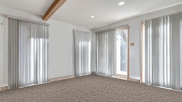 carpeted empty room with beam ceiling, recessed lighting, and a textured ceiling