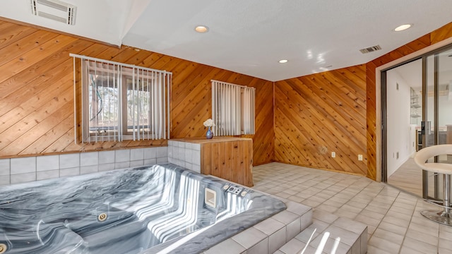 tiled bedroom featuring wooden walls and visible vents