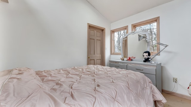 bedroom with baseboards and vaulted ceiling