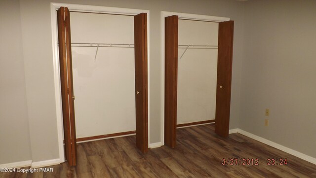 unfurnished bedroom with dark hardwood / wood-style flooring and a closet