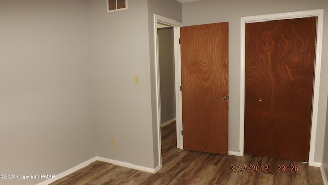 unfurnished bedroom with dark hardwood / wood-style flooring