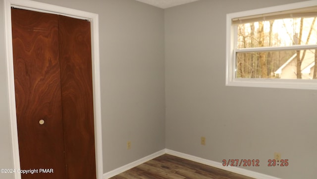 unfurnished bedroom with a closet and dark hardwood / wood-style floors