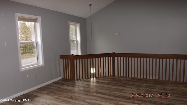 unfurnished room featuring hardwood / wood-style flooring and vaulted ceiling