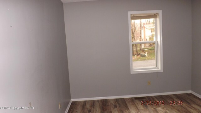 empty room with dark hardwood / wood-style flooring