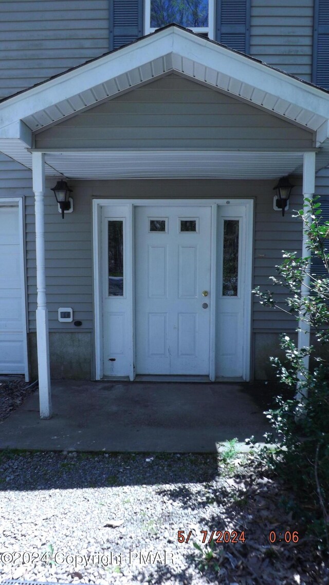 doorway to property featuring a porch and a garage