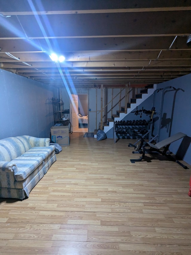 unfinished below grade area featuring wood finished floors and stairs