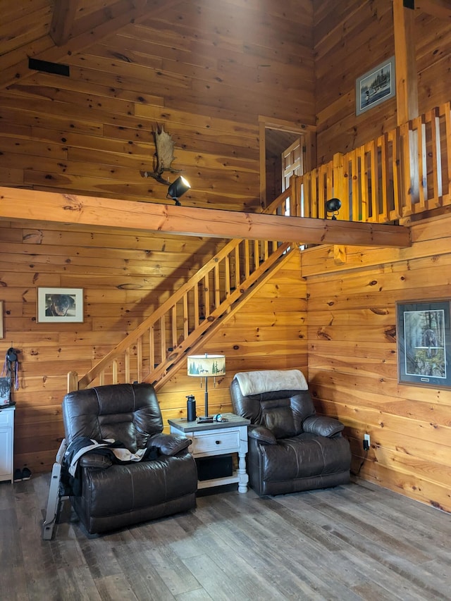 living area featuring wood walls, wood finished floors, and stairs