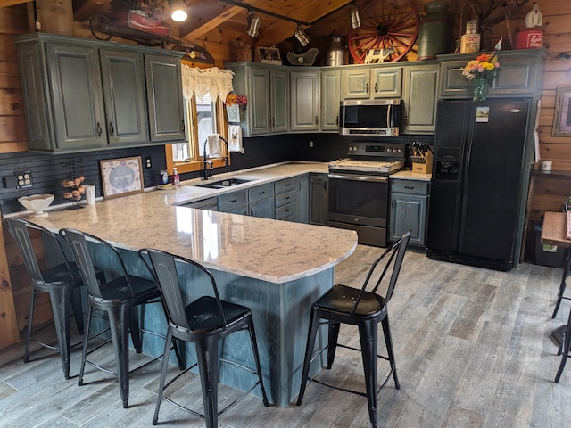 kitchen with range with electric cooktop, stainless steel microwave, a sink, black fridge, and vaulted ceiling with beams