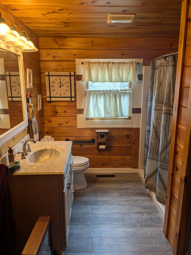 bathroom with wooden ceiling, vanity, wooden walls, toilet, and hardwood / wood-style floors