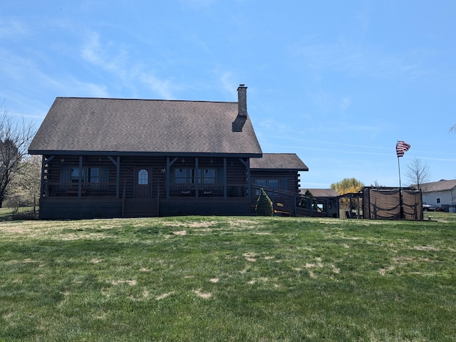 back of property with roof with shingles, a chimney, a yard, and log exterior