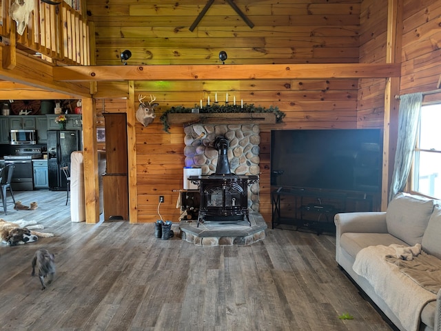 living room featuring wood walls, wood finished floors, and a wood stove
