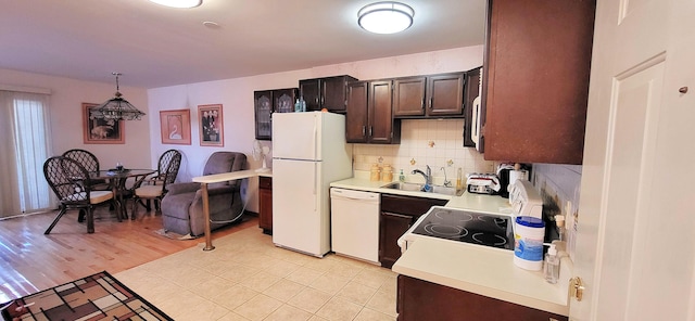 211 Falls Cir, Bushkill, PA 18324 - kitchen with light countertops, a sink, white appliances, dark brown cabinetry, and tasteful backsplash