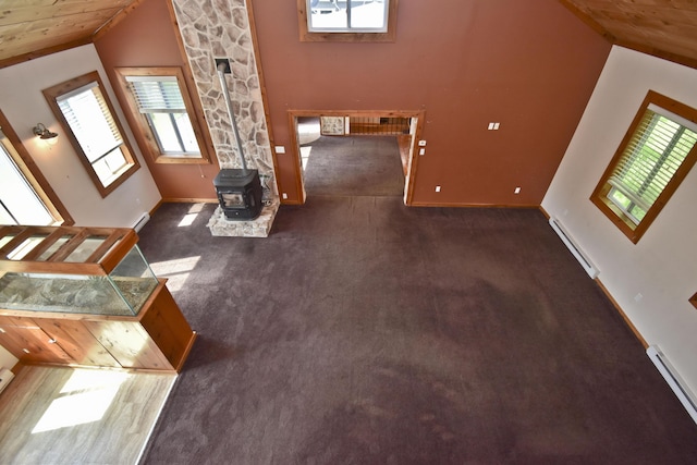 2115 Upper Smith Gap Rd, Saylorsburg, PA 18353 - unfurnished living room with a baseboard heating unit, a wood stove, healthy amount of natural light, carpet, and vaulted ceiling