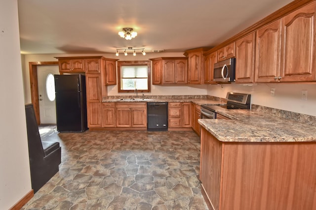 2115 Upper Smith Gap Rd, Saylorsburg, PA 18353 - kitchen featuring black appliances, dark stone finish flooring, brown cabinetry, and light stone countertops