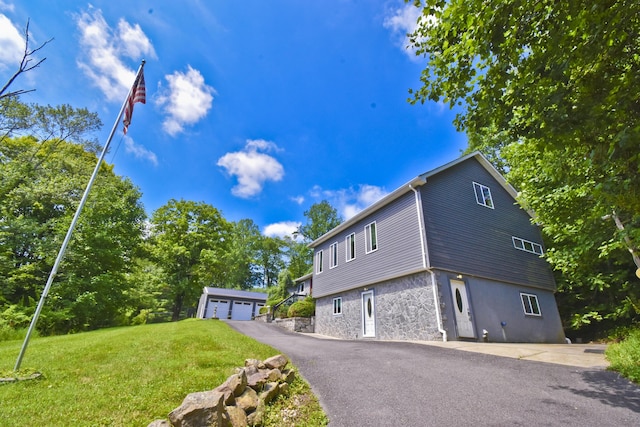 2115 Upper Smith Gap Rd, Saylorsburg, PA 18353 - view of home's exterior with stone siding, an outdoor structure, a lawn, and a garage