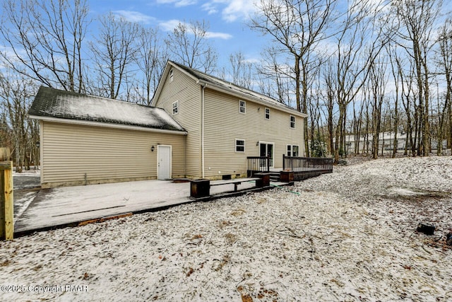 snow covered rear of property featuring a deck