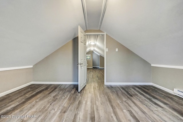 bonus room featuring lofted ceiling, baseboards, and wood finished floors